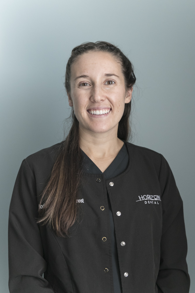 team member ashley of Horizon Dental smiling in front of blue background