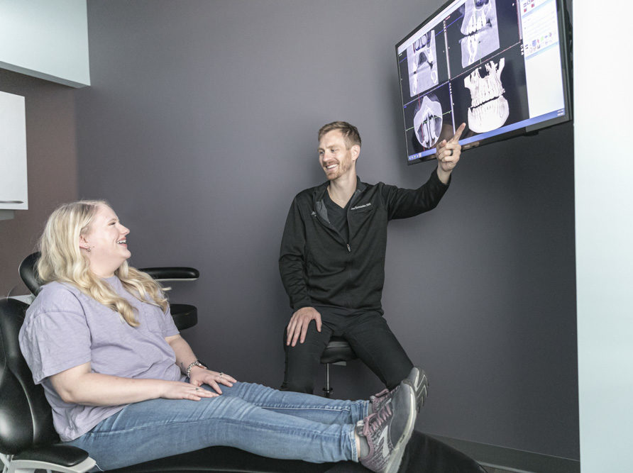 dr hostrander of horizon dental showing patient xray of teeth on screen