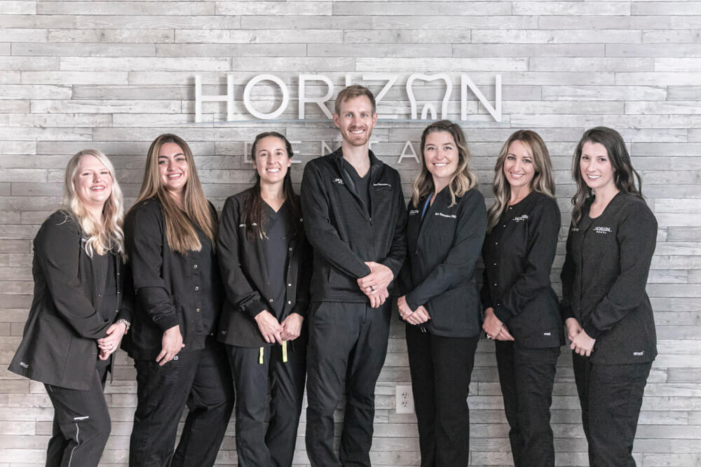 horizon dental clt team members standing in front of logo on wall
