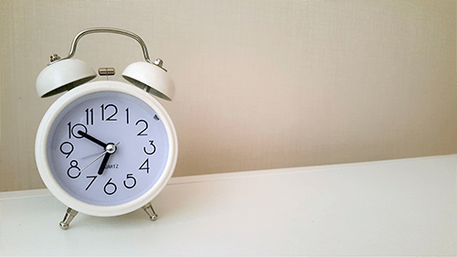 white clock on table showing the time as 6:50