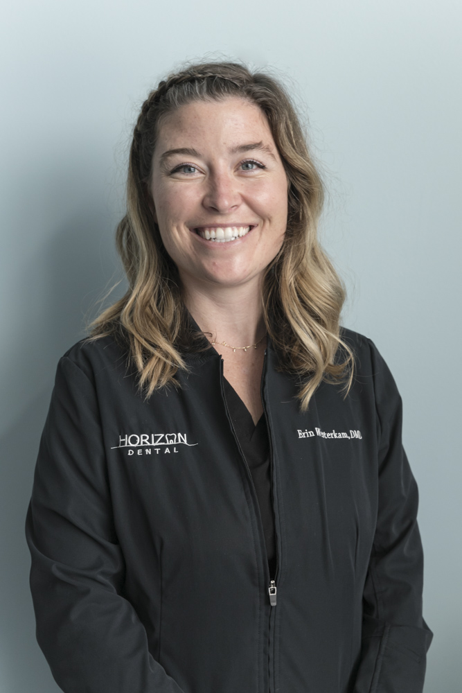 headshot of dr erin westerkam of horizon dental standing in front of blue wall
